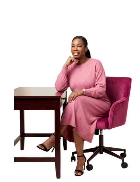 Mareaka smiling at her desk in a pink dress